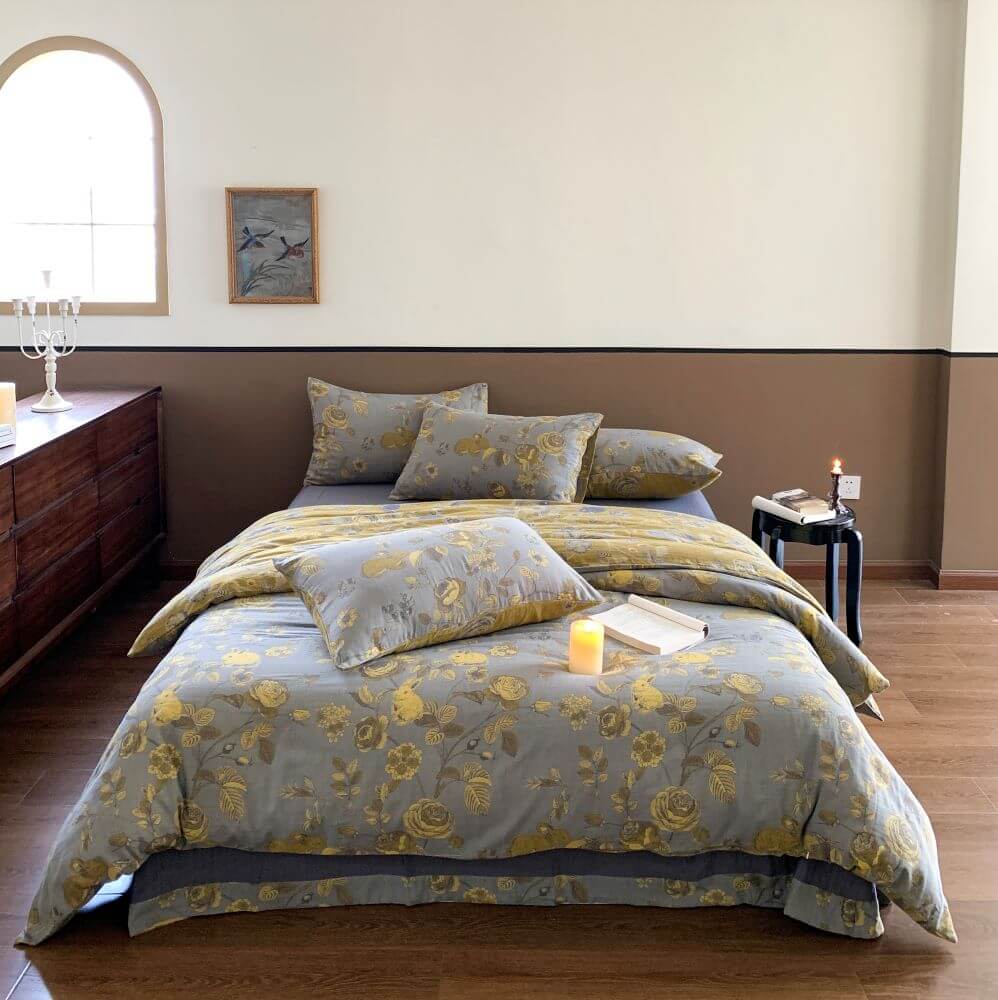 Pure washed cotton 4-piece bedding set in dusty blue with yellow rose floral pattern from Naked Cotton, styled on a queen or king size bed.